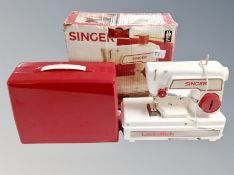 A child's vintage Singer sewing machine in box.