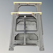 A pair of folding saw horse stands together with an adjustable saw support with roller