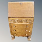 A 1930's carved oak bow fronted bureau,