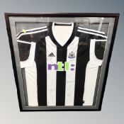 An NUFC Team signed football shirt in display frame
