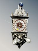 A continental wall clock with weights and pendulum