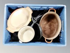 A box of four cast iron and ceramic Le Creuset pans and oven dishes