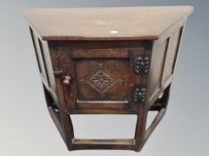 A 20th century oak shaped cabinet on raised legs