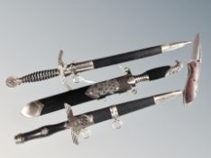 Three German WWII replica daggers in sheaths together with folding pocket knife