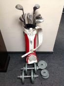 A vintage golf bag containing assorted irons and drivers, pair of dumbbells, 16 cast iron weights,