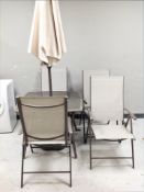 A metal framed glass topped patio table with parasol and stand together with a set of four folding