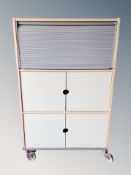 An Ikea twin cabinet with shutter door above on castors