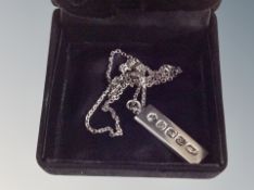 A silver chain and ingot pendant,