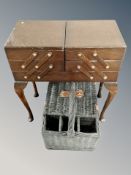 A 20th century concertina sewing box on legs and a wicker picnic basket