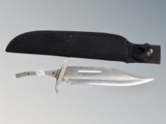 A bowie knife in sheath lacking handle