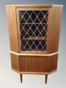 A Danish teak corner cabinet with leaded glass door