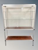 A glass and metal display cabinet with shelved interior and rosewood effect undershelf,