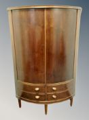 A Danish teak bow fronted corner cabinet fitted with four drawers