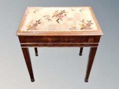 A storage footstool with needlework top