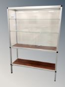 A glass and metal display cabinet with shelved interior and rosewood effect undershelf,