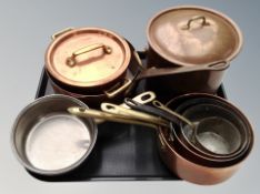 A group of copper and brass cooking pans,