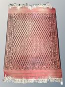 An Afghan rug on red ground,