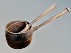 Two graduated antique cast iron pans