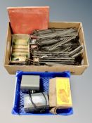 A box and crate containing 00 gauge clockwork track and accessories together with three transformer