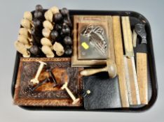 A tray of carved wooden tribal chess pieces, leather wallet,