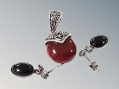 A silver pendant and earrings