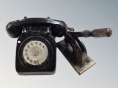 An old black telephone and cast iron company stamper