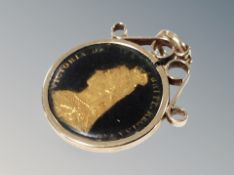 An enamel coin in 9ct gold mount