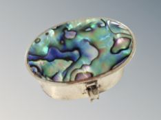 A silver mother of pearl pill box