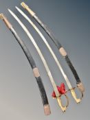 A pair of Indian swords in sheaths with lion head handles and red tassels