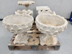 A pair of concrete urns on pedestals