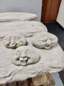 Three concrete smiling face ornaments