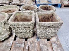A pair of weathered concrete garden planters,