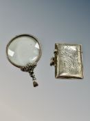 A silver match vesta and a monocle.