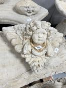A concrete cherub wall pocket,