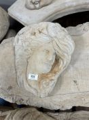 A concrete wall pocket in the form of a maiden,