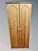A contemporary pine double door wardrobe,
