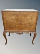 A figured walnut drinks cabinet on cabriole legs,