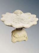 A concrete shell bird bath on pedestal,