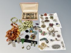 A collection of Art Deco style paste brooches, several pairs of earrings, Baltic amber necklaces,