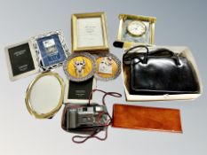 A box of contemporary picture frames, mantel clock, camera,
