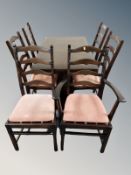 An Ercol stained elm extending dining table together with six ladder backed chairs