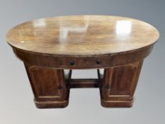 A 19th century rosewood oval twin pedestal partners desk fitted with four drawers,