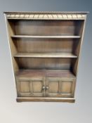 An Ercol stained elm bookcase fitted with cupboards,