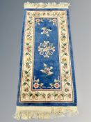 A Chinese rug on blue ground 62 cm x 122 cm