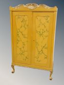 A Continental gilded and painted double door wardrobe on claw and ball feet,
