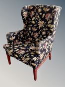 A 20th century wing backed armchair in floral upholstery