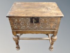 A late 18th century carved oak bible box on stand,