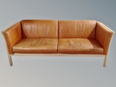 A late 20th century Danish three seater tan leather settee,