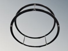 A circular metal display stand, lacking shelves,