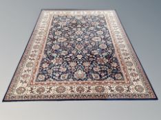 A machine made carpet of Persian design on Indigo ground,